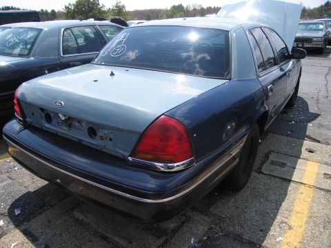 2001 Ford Crown Victoria - This 2001 Ford Crown Victoria is seen from the rear with its hood open, parked next to another vehicle.