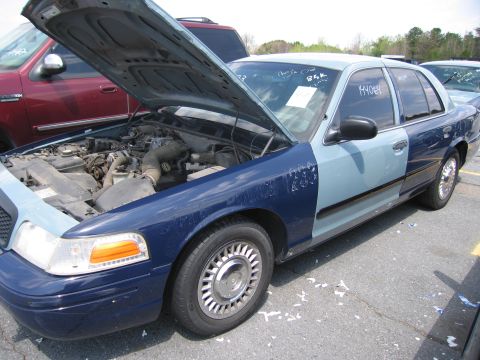 2001 Ford Crown Victoria - A two-tone 2001 Ford Crown Victoria sits with its hood open, revealing the engine compartment.