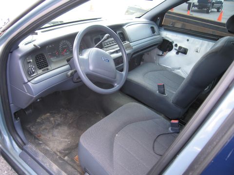 2001 Ford Crown Victoria - The interior of a 2001 Ford Crown Victoria, with the driver's side door panel removed, revealing exposed wiring and insulation.