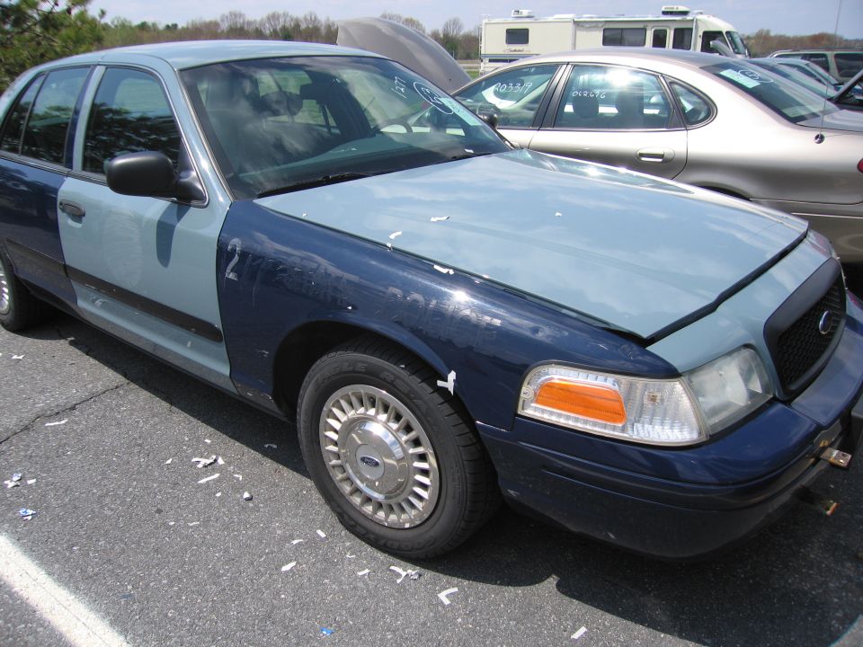 Two-tone Ford Crown Victoria, front right side. Hood is up