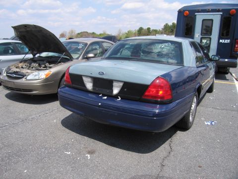 2001 Ford Crown Victoria - Rear view of a blue and gray 2001 Ford Crown Victoria parked next to another vehicle.