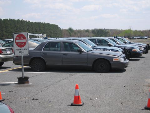 2001 Ford Crown Victoria - Several police cars, including a 2001 Ford Crown Victoria, are parked in a lot with a 'Do Not Enter' sign.