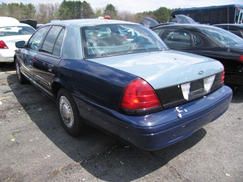 2001 Ford Crown Victoria - This 2001 Ford Crown Victoria is seen in a junkyard with other vehicles.