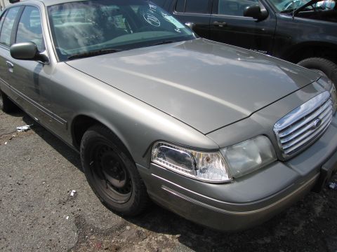 2001 Ford Crown Victoria - Front view of a 2001 Ford Crown Victoria, parked outdoors next to another vehicle.