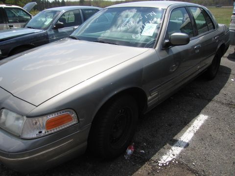 2001 Ford Crown Victoria - A gray 2001 Ford Crown Victoria is parked in a lot with another vehicle visible behind it.