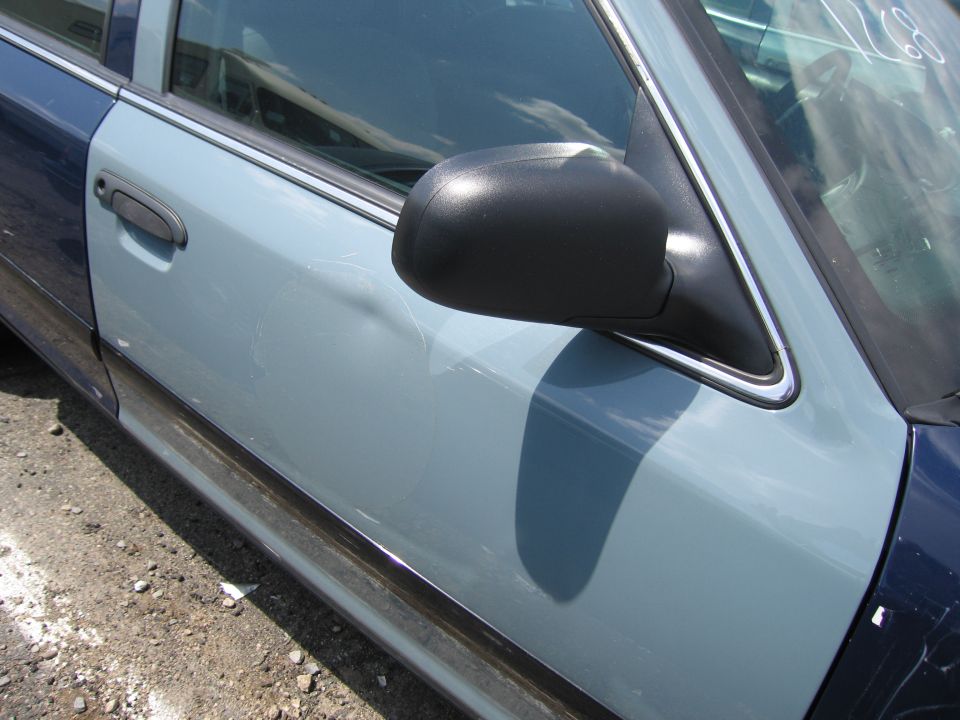 Two-tone car door with black side mirror and chrome trim