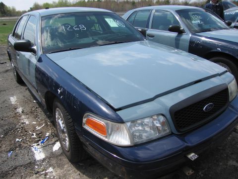 2001 Ford Crown Victoria - Front view of a 2001 Ford Crown Victoria with a two-tone paint job, parked next to another similar vehicle.