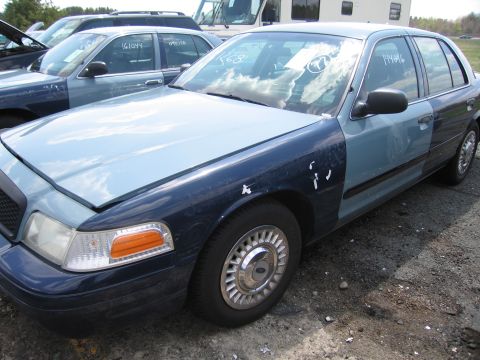 2001 Ford Crown Victoria - This Ford Crown Victoria has two-tone paint and appears to be in a junkyard or impound lot.