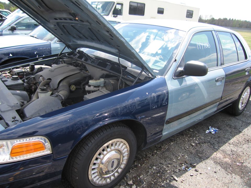 Blue and light blue Ford Crown Victoria with hood open, showing engine. Number 199706 written on window
