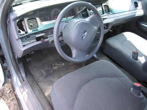 2001 Ford Crown Victoria - The interior of a 2001 Ford Crown Victoria shows a worn dashboard and seats.