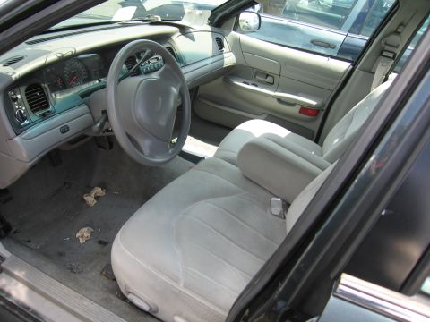 2001 Ford Crown Victoria - The interior of a 2001 Ford Crown Victoria shows light-colored cloth seats and a gray dashboard.