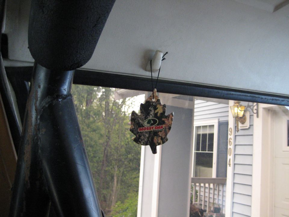 Mossy Oak leaf-shaped air freshener hanging from a white clip inside a vehicle.