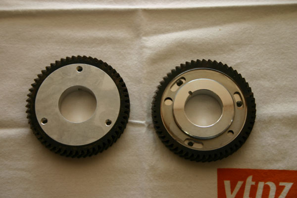 Two metallic gears with teeth, one with a plain center and one with a keyway.