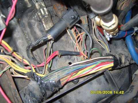 1989 Ford Bronco - A close-up view of a complex wiring harness with many colored wires, some taped together, in what appears to be an engine bay. A timestamp…