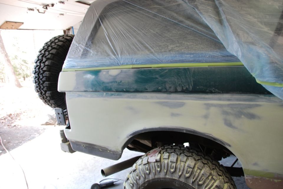 Photo of a truck bedside panel in primer with masking tape