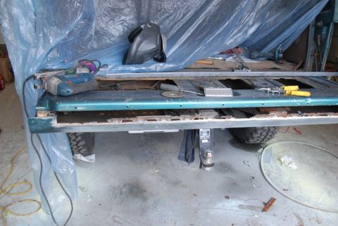 1996 Ford Bronco - Photograph of a disassembled truck bed panel on a workbench during restoration, not a technical document.