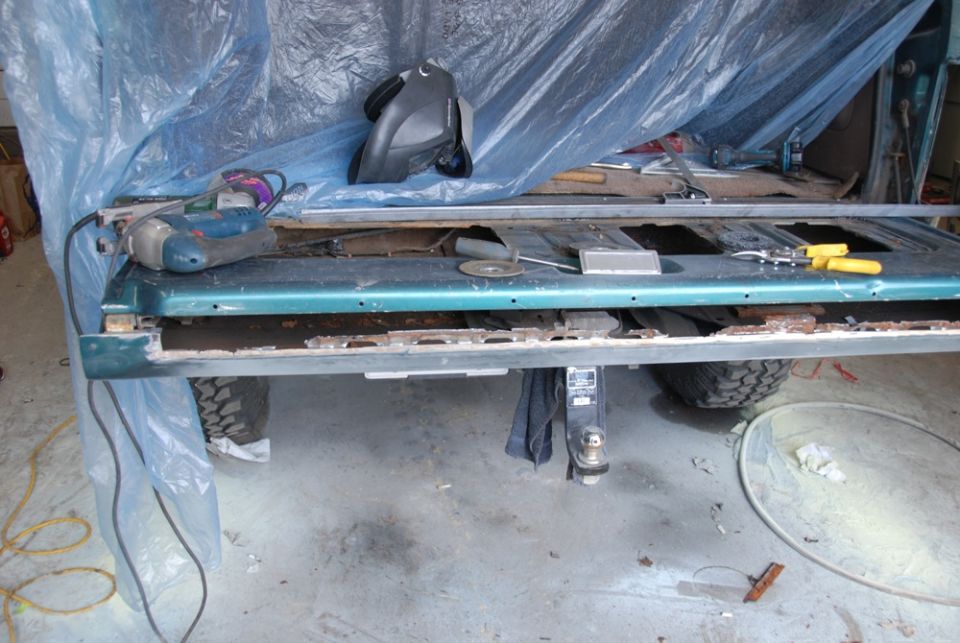 Photo of a removed truck bed side panel on stands with tools
