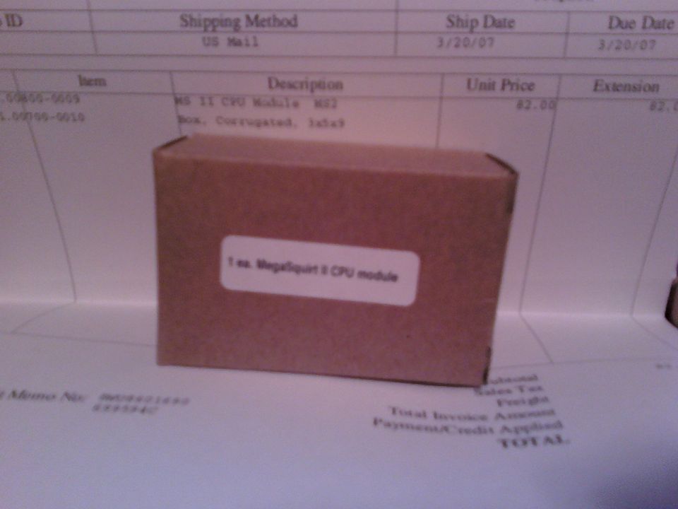 Cardboard box with "MegaSquirt II CPU module" label on top of an invoice.