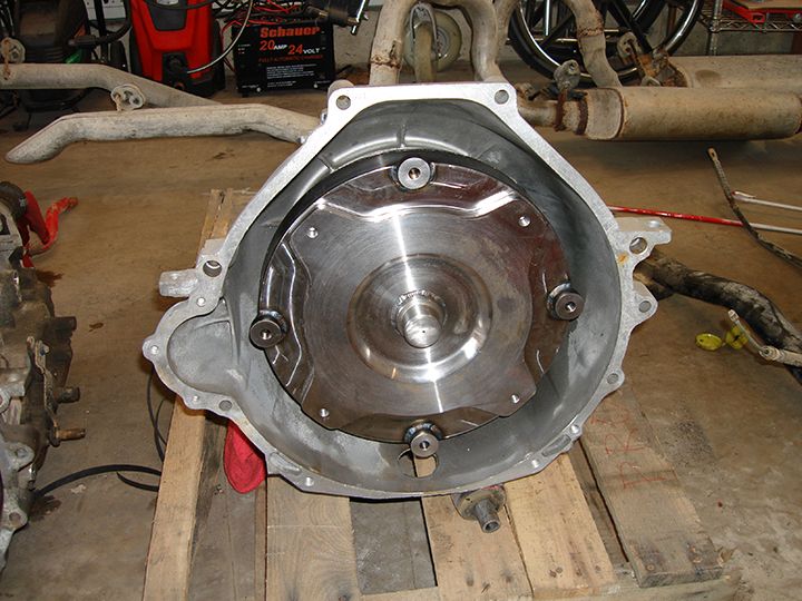 Torque converter inside transmission bell housing, resting on pallets.