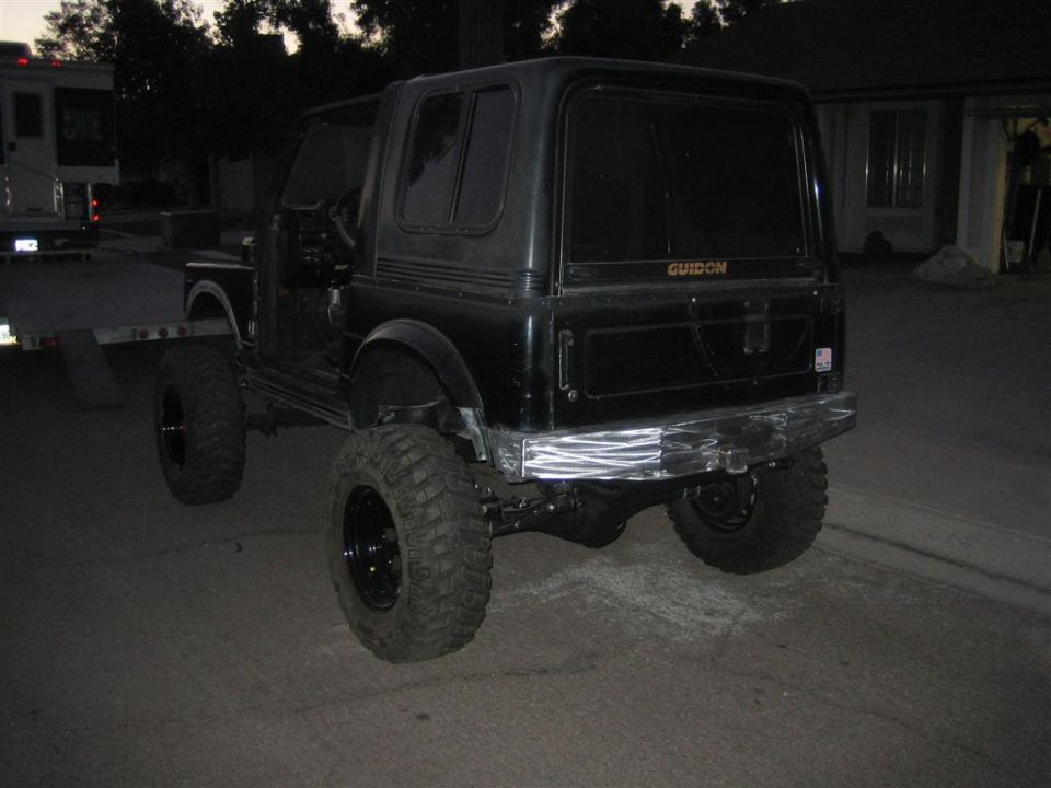 Lifted black Suzuki Samurai rear 3/4 at dusk with hardtop and aluminum rear bumper