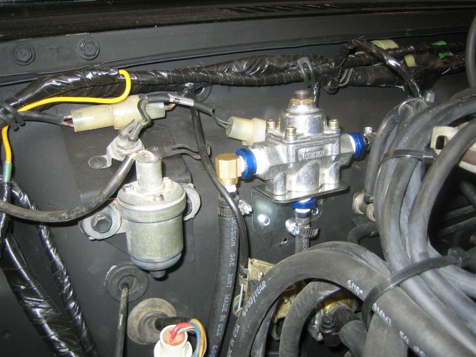 Engine bay with fuel pressure regulator, hoses, and wiring.