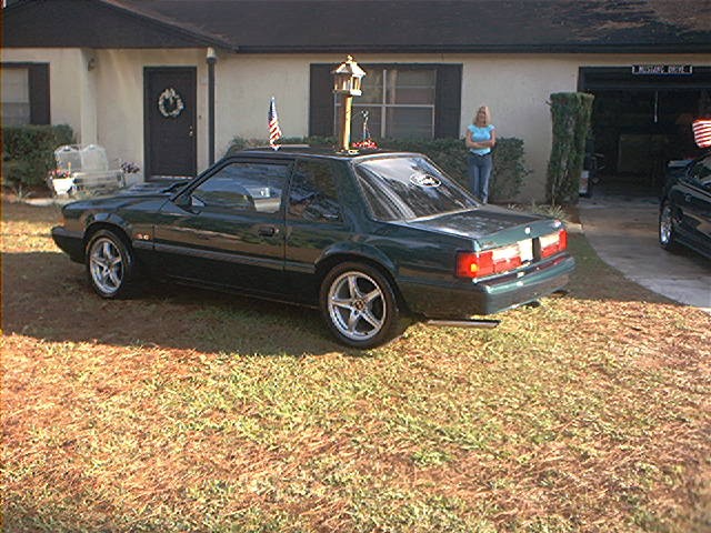 Dark green Fox-body Ford Mustang 5.0 hatchback parked on a lawn