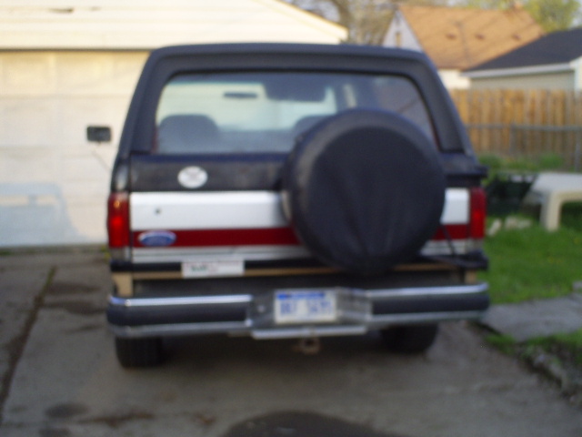 Rear view of a dark Ford Bronco with a spare tire on the back.