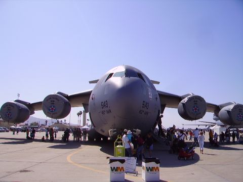 1990 Ford Bronco - A large, gray military cargo plane, identified as "5143 TEAM MARCH 452 AMW", is parked on an airfield with a crowd of people gathered aroun…