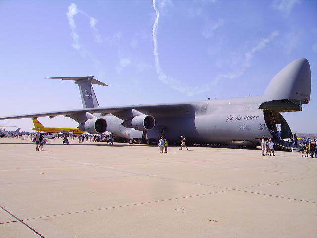 U.S. Air Force cargo plane with rear cargo door open on an airfield.