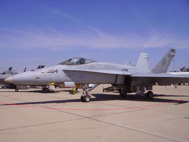 Gray U.S. Navy F/A-18 Hornet fighter jet parked on an airfield.