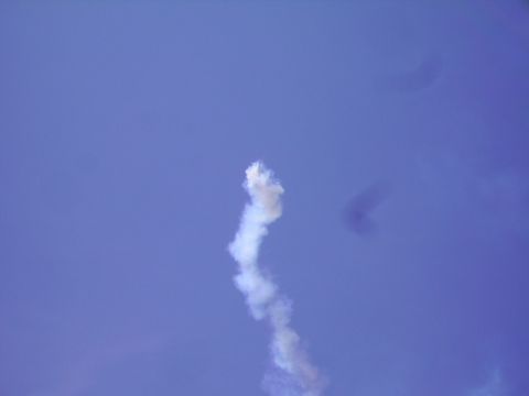 1990 Ford Bronco - A plume of white smoke trails upwards against a clear blue sky.