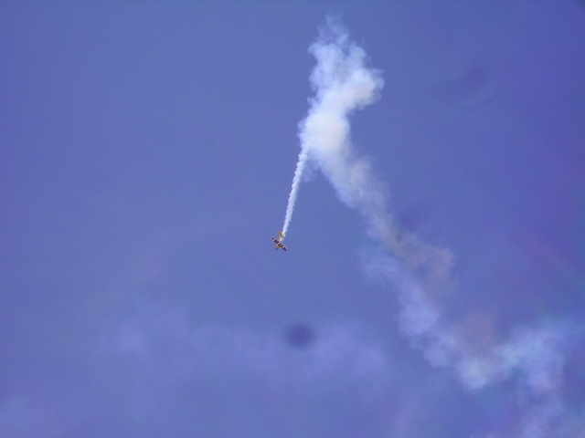 Airplane performing an aerial stunt with a smoke trail.