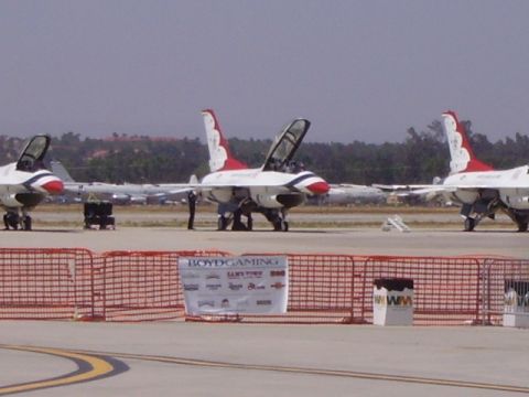 1990 Ford Bronco - Three U.S. Air Force Thunderbirds F-16 fighter jets are parked on an airfield, with one jet's canopy open. A red safety fence and a banner…
