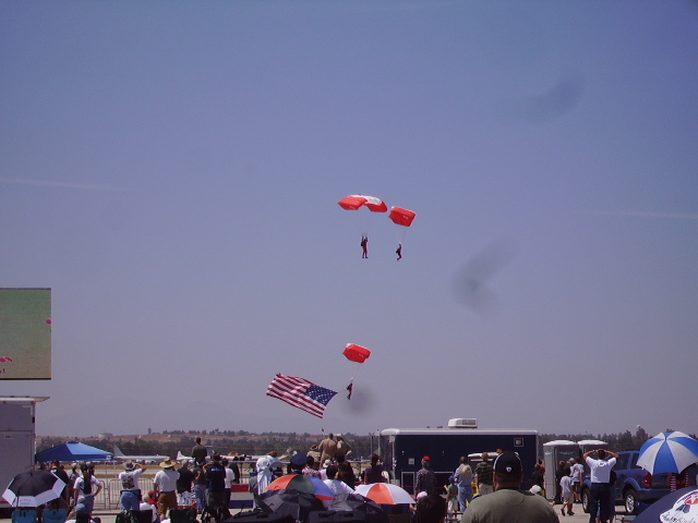 Parachutists descending against a clear blue sky