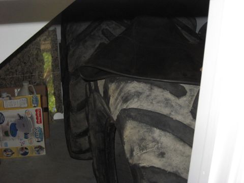 2006 Ford F-150 - A collection of large, worn tractor tires are stored indoors, with a child's potty training seat box visible.
