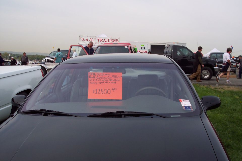 Dark sedan with a "For Sale" sign on the windshield.