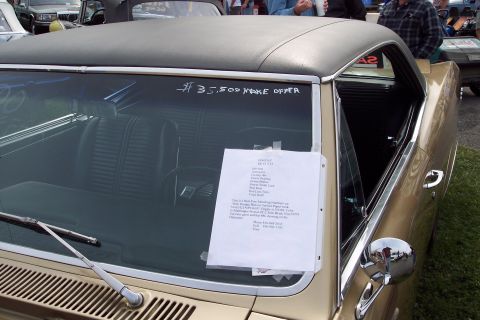 2001 Ford Crown Victoria - A gold coupe with a black vinyl top is parked outdoors with a for sale sign on its windshield.
