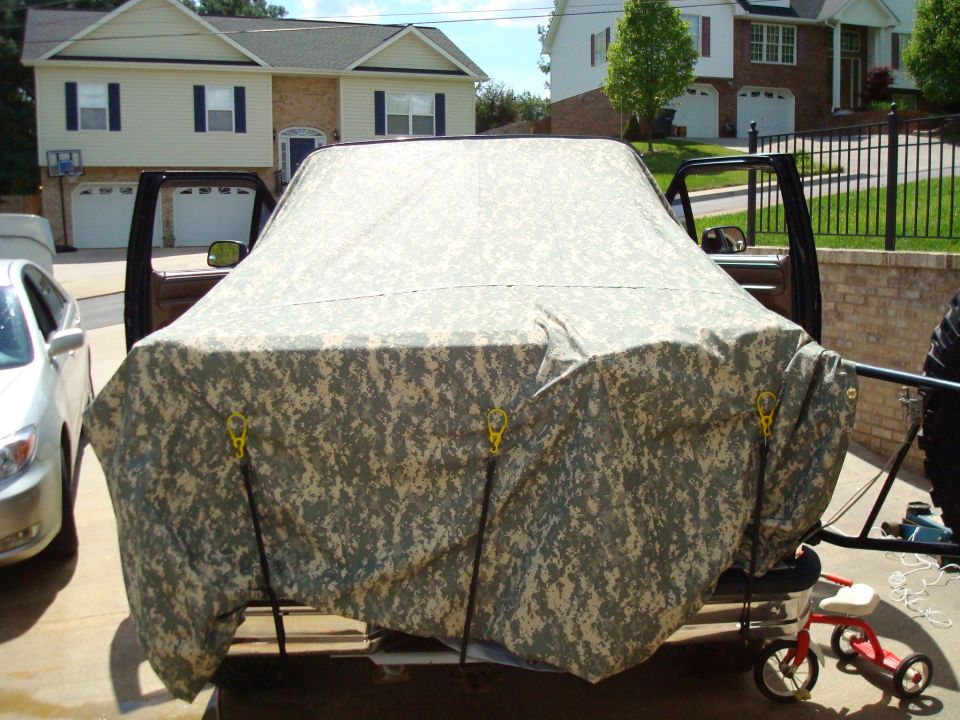 Vehicle covered in camouflage tarp with doors open