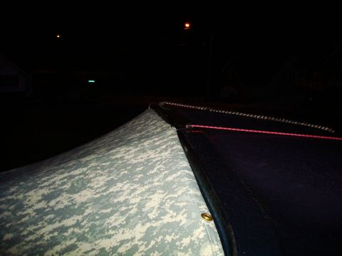 1995 Ford Bronco - A camouflaged soft top is visible at night, with a red rope running along its edge.