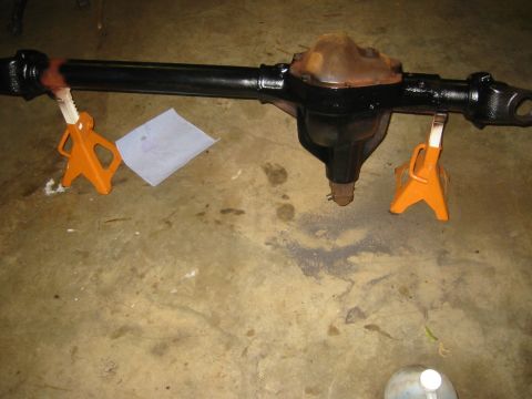 1995 Ford Bronco - A rear axle assembly is shown supported by two orange jack stands on a concrete floor.