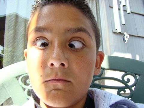 1989 Ford Bronco - A young boy makes a funny face by crossing his eyes while looking at the camera.