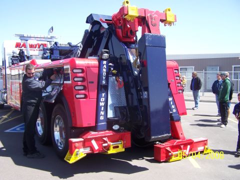 1972 Ford Ranchero - A tow truck with "Randy's Towing" branding is shown from the rear, with a man attending to its side.
