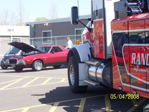 1972 Ford Ranchero - A red 1972 Ford Ranchero is parked with its hood up, alongside a large tow truck.