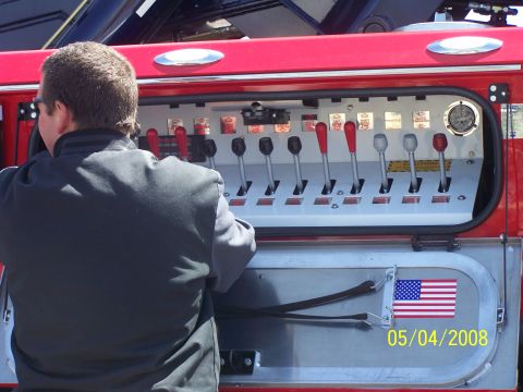1972 Ford Ranchero - Close-up of a fire truck's control panel, numerous levers and a gauge. An American flag sticker is present.