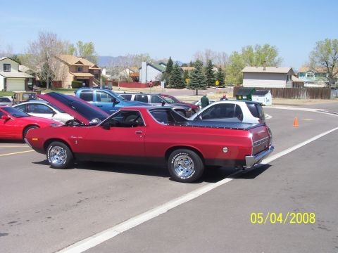 1972 Ford Ranchero - Red 1972 Ford Ranchero on display with hood up, parked next to other vehicles.