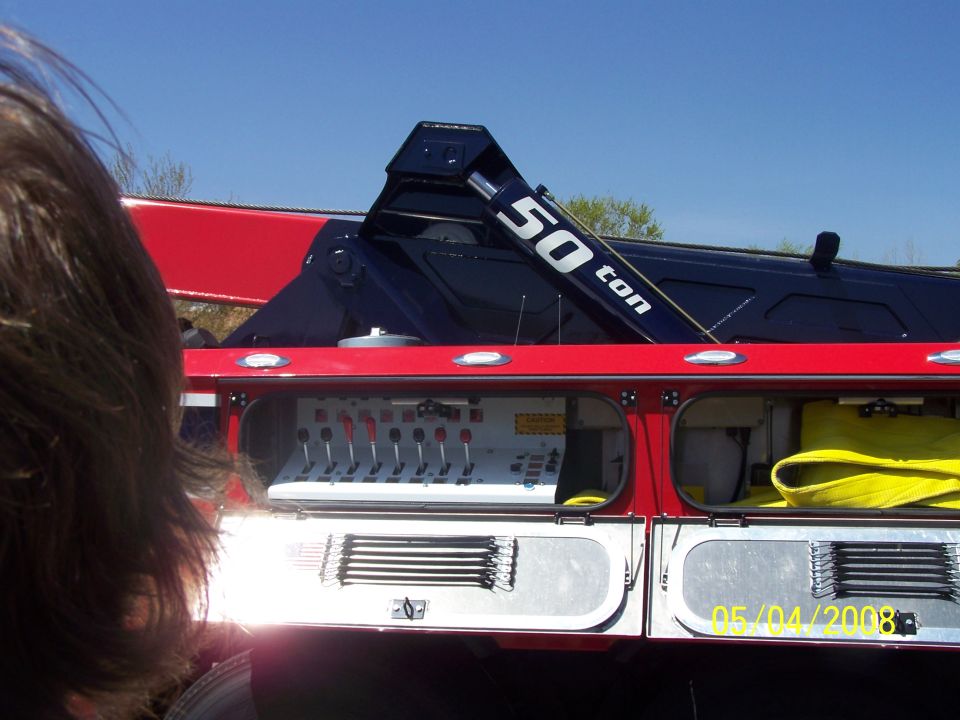 Red tow truck with a blue crane labeled "50 ton", control panel visible