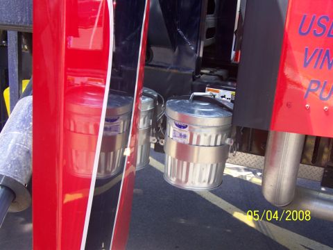 1972 Ford Ranchero - Two galvanized trash cans are mounted to the exterior of a red vehicle.