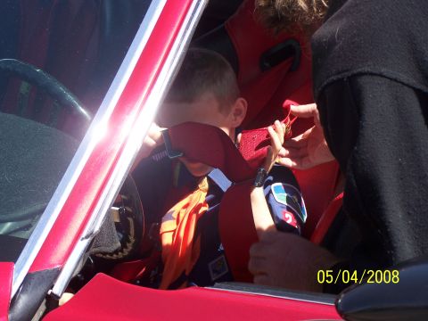 1972 Ford Ranchero - A child is being secured in a racing seat with a safety harness.