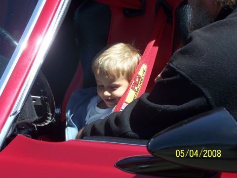 1972 Ford Ranchero - A young child sits in a red racing seat with a red RCI harness, looking down.