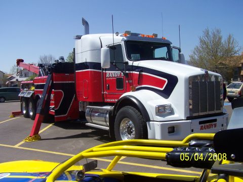1972 Ford Ranchero - A large tow truck is parked outdoors, with a yellow vehicle in the foreground.